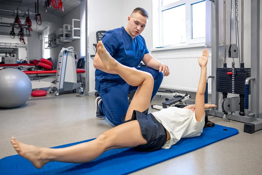 Physiotherapist guiding a patient with Ehlers-Danlos Syndrome through movement therapy exercises