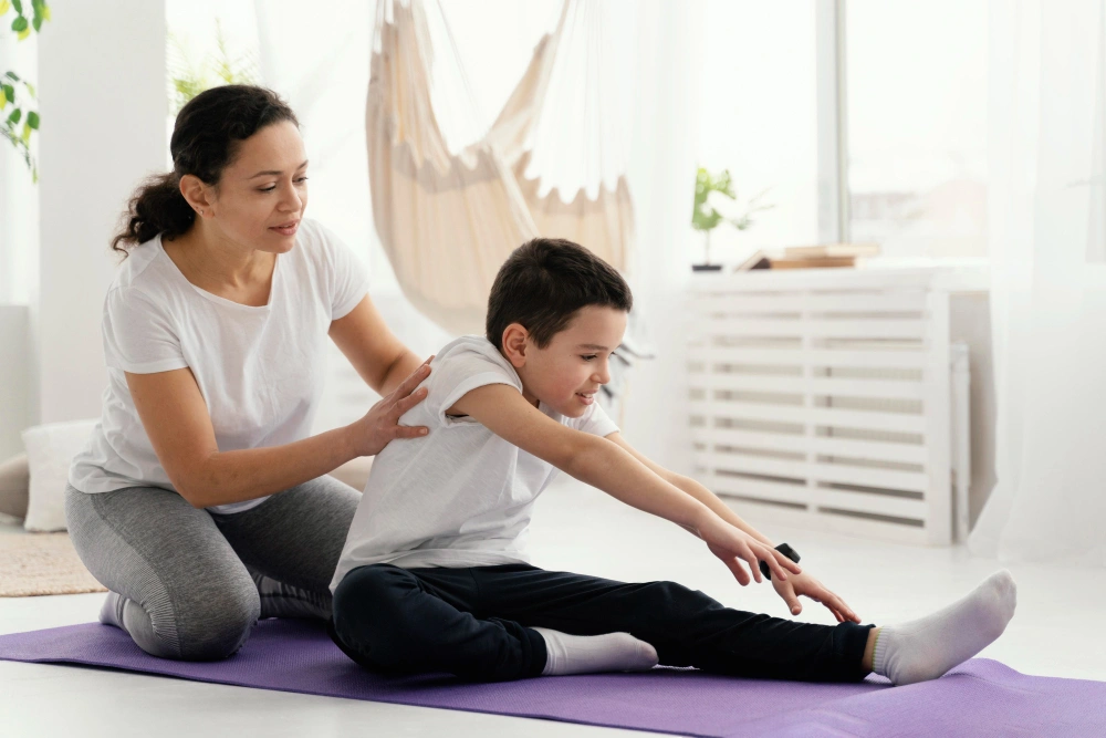 Paediatric physiotherapist guiding a young boy during a stretching session in Bangalore