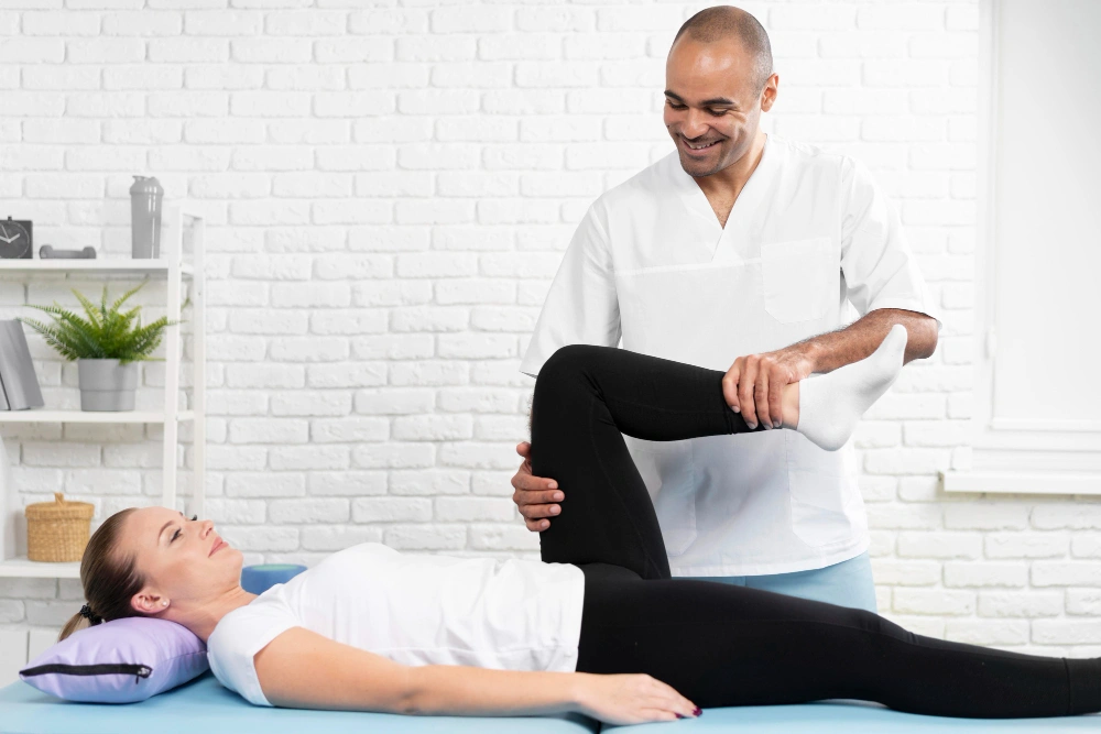 Physiotherapist helping patient with leg movement during a rehabilitation session